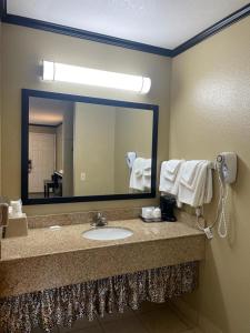 La salle de bains est pourvue d'un lavabo et d'un grand miroir. dans l'établissement Super 8 by Wyndham Crescent City, à Crescent City