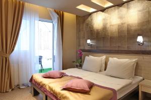 Postel nebo postele na pokoji v ubytování Garni Hotel Vozarev + 29 fotografií