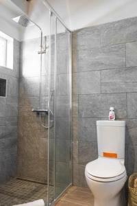 a bathroom with a toilet and a glass shower at Tradewinds Apartments Simpson Bay in Simpson Bay