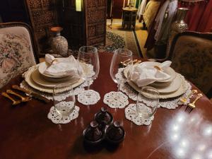 a wooden table with plates and glasses on it at MAGICAL MOROCCAN TENT WITH POOL CLOSE TO THE BEACH in Fort Pierce