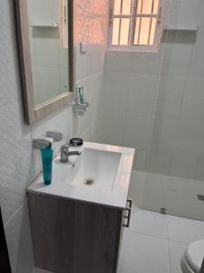 Un baño blanco con lavabo y ducha. en Arena Confort, en Punta Cana