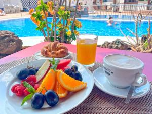 un tavolo con un piatto di frutta e una tazza di caffè di Fairways Club a San Miguel de Abona