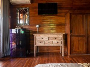 登巴薩的住宿－Pondok Biu，一间房间,墙上装有梳妆台和电视机