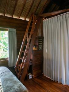 een slaapkamer met een houten trap in een kamer bij Pondok Biu in Denpasar