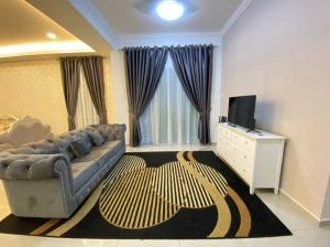 a living room with a couch and a television at 13StayCation Islamic Homestay in Malacca