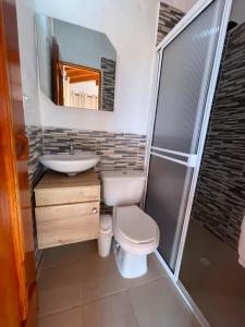a bathroom with a toilet and a sink and a shower at Finca-hotel Montecarlo Guatape by Hope in Guatapé