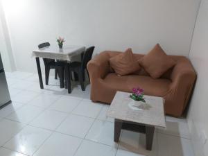 a living room with a couch and a table at Affordable Tagaytay Monteluce 1 BR WITH POOL in Lalaan Primero