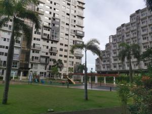 a park with a playground in front of tall buildings at Affordable Tagaytay Monteluce 1 BR WITH POOL-224 in Lalaan Primero