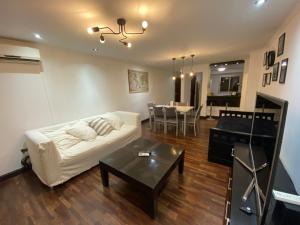 een woonkamer met een witte bank en een tafel bij Departamento Salta Nuevo Encuentro in Salta