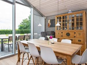 una sala da pranzo con tavolo in legno e sedie bianche di Holiday home Juelsminde LXXXIII a Juelsminde