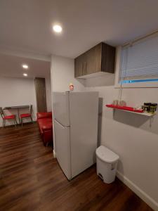 een keuken met een koelkast en een rode bank bij Auberge Motel LA RÉFÉRENCE in Trois-Rivières