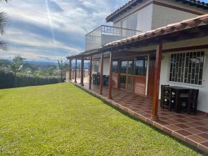 a house with a large lawn in front of it at Finca-hotel Montecarlo Guatape by Hope in Guatapé +31 photos