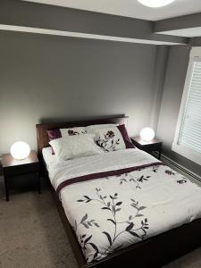 a bedroom with a bed with two lamps on tables at Lovely 2 bedroom 2 bathroom plus den in Calgary