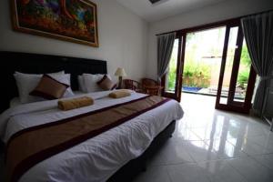 a bedroom with a large bed in a room at Surya Guest House Sanur in Sanur