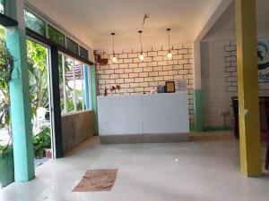 a lobby with a white counter in a room with windows at Maafushi View in Maafushi