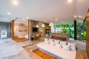a living room with a white couch and a television at ROMANTIC GETAWAY - ARCHITECTURAL MASTERPIECE 1BR in Canggu