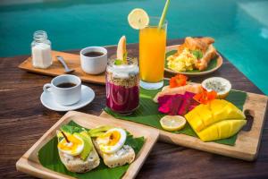 a table with two plates of breakfast foods and drinks at ROMANTIC GETAWAY - ARCHITECTURAL MASTERPIECE 1BR in Canggu