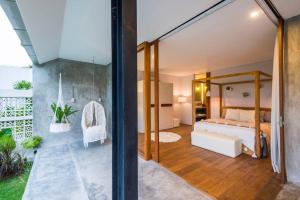 a bedroom with a bed and a glass wall at ROMANTIC GETAWAY - ARCHITECTURAL MASTERPIECE 1BR in Canggu