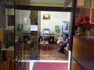 a person sitting on a couch in a living room at HOTEL WENDY MAR in Copacabana
