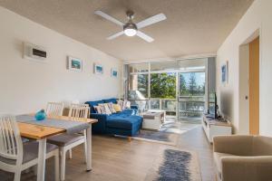 a living room with a blue couch and a table at Crystal Waters 2 2 Munster Street in Port Macquarie