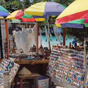 a market with umbrellas and other items for sale at Gili Mesari Cottages & Homestay in Gili Trawangan