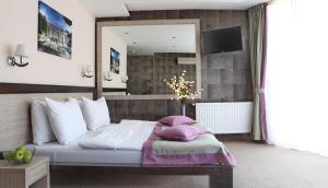 ein Schlafzimmer mit einem Bett und einem großen Spiegel in der Unterkunft Garni Hotel Vozarev in Belgrad