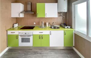 a kitchen with green and white cabinets and a sink at 3 Bedroom Awesome Apartment In Estepona in Estepona