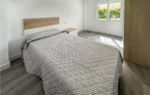 a bedroom with a bed with a comforter and a window at 3 Bedroom Awesome Apartment In Estepona in Estepona