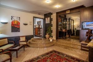 a lobby with a couch and a tv and stairs at Mannu Hotel in Bosa