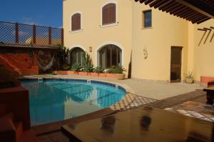 a swimming pool in front of a house at El Mosaico Del Sol in Lampedusa