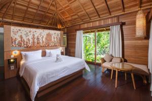 une chambre avec un lit, une table et une fenêtre dans l'établissement Giriwood Hotel & Villa, à Munduk