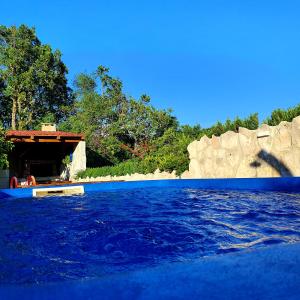 - une piscine d'eau bleue en face d'un bâtiment dans l'établissement Apartman Gizdavac, à Gizdavac