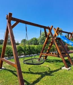 une balançoire dans un parc avec une aire de jeux dans l'établissement Domki Słoneczne Zacisze, à Ustka