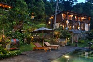 Seraya的住宿－Loids Villa Eco Lodge Lempuyang，游泳池旁带遮阳伞的房子