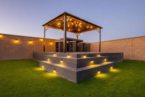 a building with a gazebo with lights on the grass at 1900 SqFt House W/25Ft Heated Pool/Spa- Strip View in Henderson