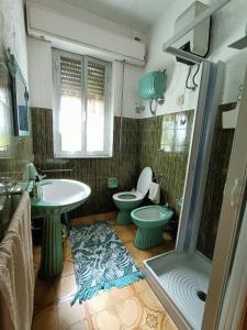 ein Badezimmer mit 2 WCs und einem Waschbecken in der Unterkunft Ghiramonte, vita in campagna a due passi dal mare in Siniscola