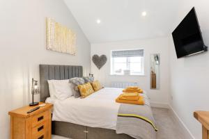 a bedroom with a bed with a tv on the wall at Eames Cottage in Cowling