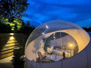 una cúpula de cristal con sala de estar. en Bulle du puits avec jacuzzi et sauna privatif, 