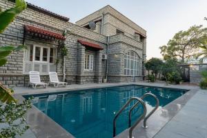 a swimming pool in front of a house at Sajjan Niwas in Udaipur