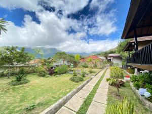 - un jardin avec une passerelle en pierre dans une cour dans l'établissement Sembalun Kita Cottage, à Sembalun Lawang