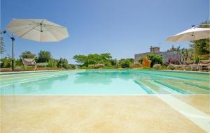 una piscina con sombrilla y sillas en Stunning Home In Cisternino With Wifi, en Cisternino