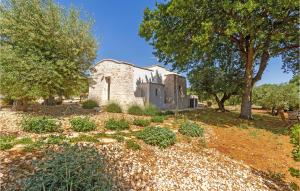 una vieja casa de piedra con árboles delante de ella en Stunning Home In Cisternino With Wifi, en Cisternino