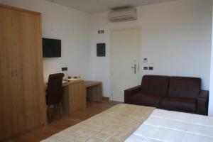 1 dormitorio con cama, escritorio y silla en Villa Eva Hotel, en Ventimiglia