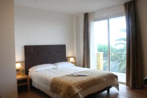 a bedroom with a large bed and a large window at Villa Eva Hotel in Ventimiglia