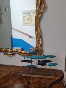 a mirror next to a table with blue surfboards at Villa Lisa - La quiete e il profumo del mare in Grado