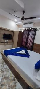 a bedroom with a bed with a blue blanket on it at HOTEL BEST BUY in Kolkata