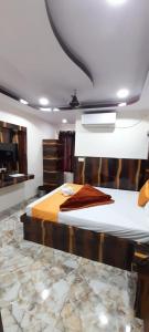 a bedroom with a large bed with a wooden headboard at HOTEL BEST BUY in Kolkata