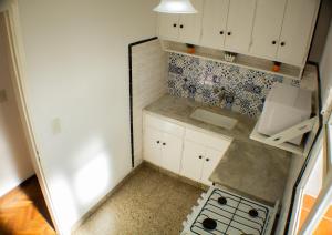 a small kitchen with white cabinets and a sink at Piazza Mendoza in Mendoza +49 photos