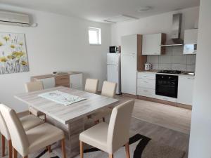 a kitchen and dining room with a wooden table and chairs at Kuća za odmor Balera in Šumarina