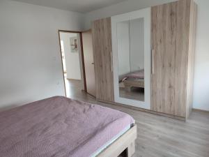una camera da letto con un letto e un grande specchio di Kuća za odmor Balera a Šumarina